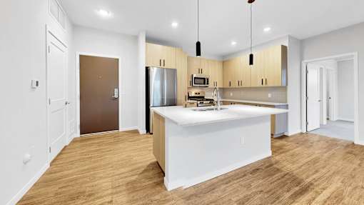 A kitchen with a white island and wooden floors.