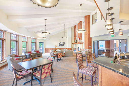 a large lobby with tables and chairs and a kitchen