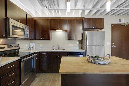 A kitchen with wooden cabinets and a refrigerator.