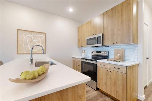 A modern kitchen with wooden cabinets and a white countertop.