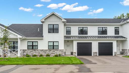 A large white house with a black garage door.