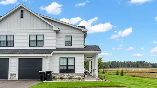 A white house with a black garage door.