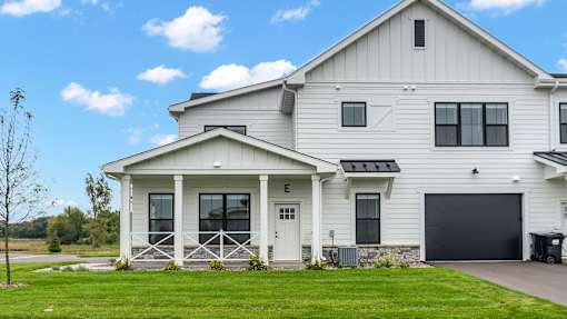 A white house with a black garage door.