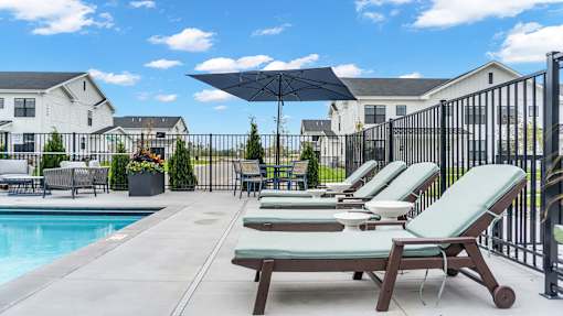A poolside area with lounge chairs and umbrellas.