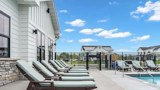 A row of lounge chairs are set up on a patio.