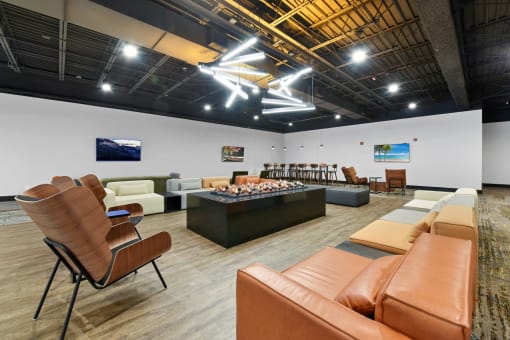 a large room with couches and chairs and a fire place in the middle of the room