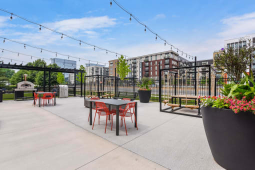an outdoor patio with tables and chairs and a fire pit