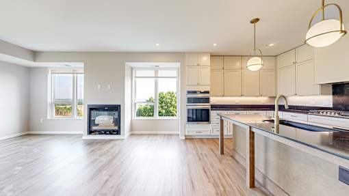 a large kitchen with a fireplace and a large island at Ardor on the Bluffs South Loop Residences Apartments, Bloomington, MN, 55425
