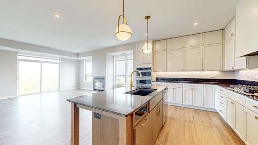 a large kitchen with an island in the middle at Ardor on the Bluffs South Loop Residences Apartments, Bloomington, MN