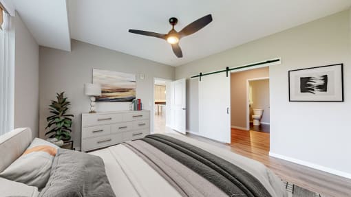 a bedroom with a bed and a ceiling fan at Ardor on the Bluffs South Loop Residences Apartments, Bloomington, 55425