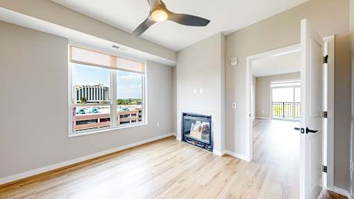 a living room with wood floors and a fireplace     and a window at Ardor on the Bluffs South Loop Residences Apartments, Bloomington, MN