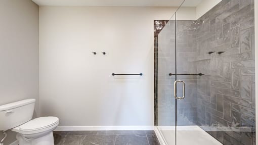 a bathroom with a toilet and a glass shower at Ardor on the Bluffs South Loop Residences Apartments, Minnesota, 55425
