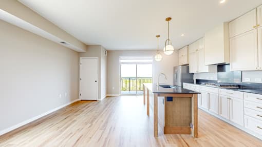 an open kitchen and living room with a wood floor at Ardor on the Bluffs South Loop Residences Apartments, Bloomington, MN, 55425