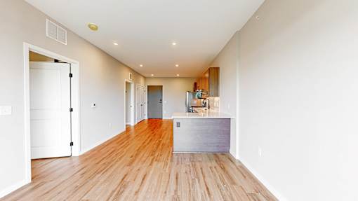 a living room and kitchen with wood floors and white walls at Ardor on the Bluffs South Loop Residences Apartments, Bloomington, MN, 55425