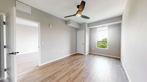 an empty living room with wood floors and a ceiling fan at Ardor on the Bluffs South Loop Residences Apartments, Minnesota, 55425