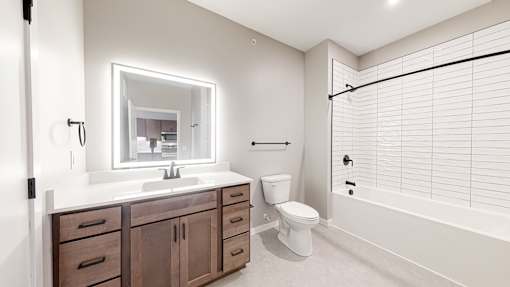a bathroom with a sink toilet and a shower at Ardor on the Bluffs South Loop Residences Apartments, Minnesota