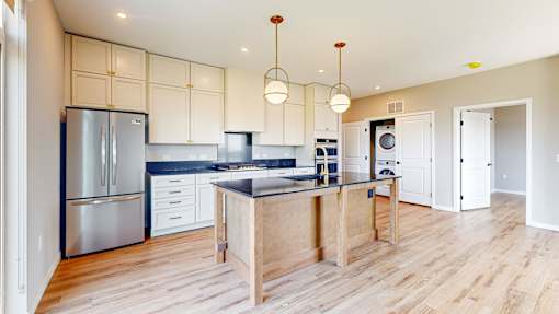 A modern kitchen with wooden floors and stainless steel appliances.