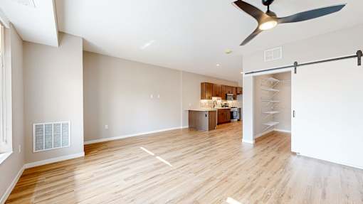 A room with a ceiling fan and a wooden floor.