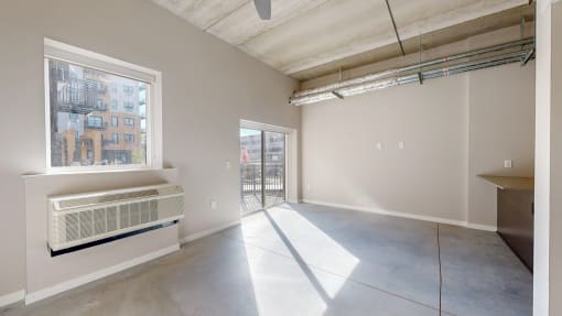 an empty living room with a large window and concrete floors at Ardor on the Bluffs South Loop Residences Apartments, Bloomington, 55425