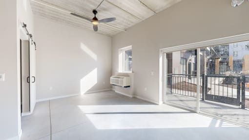 A spacious room with a ceiling fan and sliding glass doors. at Ardor on the Bluffs South Loop Residences Apartments, Bloomington, Minnessota