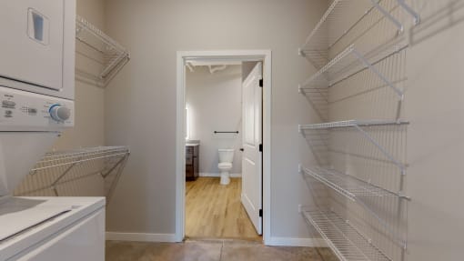 A white kitchen with a doorway leading to a bathroom at Ardor on the Bluffs South Loop Residences Apartments, Bloomington, MN, 55425