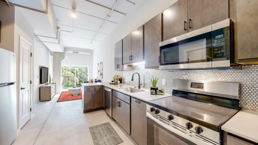 a modern kitchen with stainless steel appliances and cabinets at Ardor on the Bluffs South Loop Residences Apartments, Bloomington