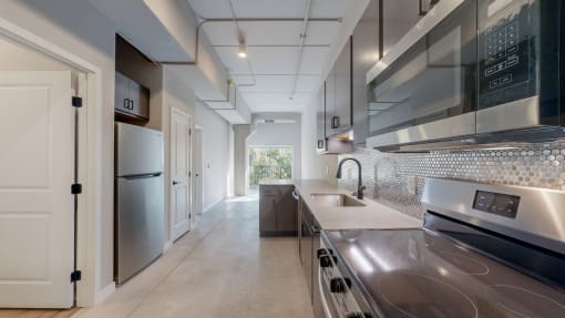 a kitchen with stainless steel appliances and a stainless steel counter top at Ardor on the Bluffs South Loop Residences Apartments, Bloomington