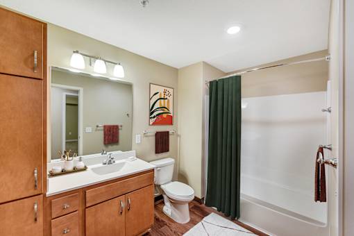 A bathroom with a toilet, sink, and shower.