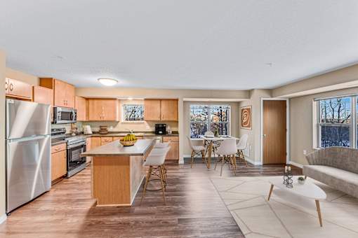A kitchen with a refrigerator, oven, and sink.