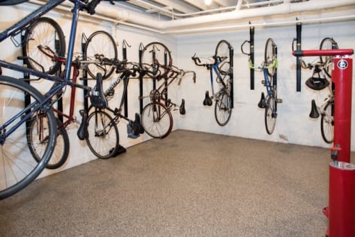 a bike room with several bikes hanging on the wall and a red fix-it station