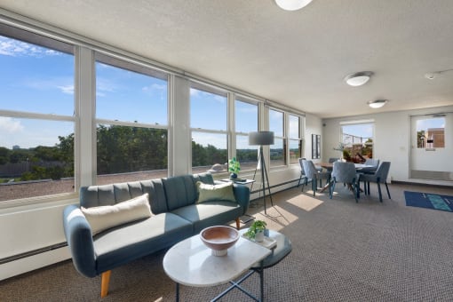 a living room with a couch and a table and windows