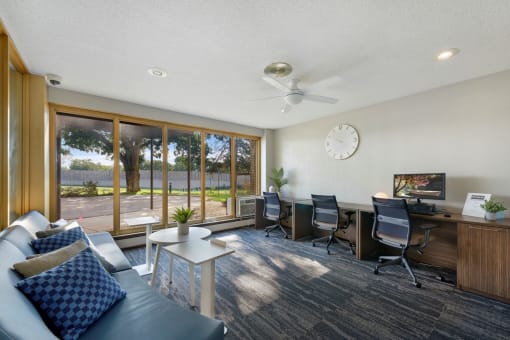 a living room with a couch and a desk with a clock on the wall