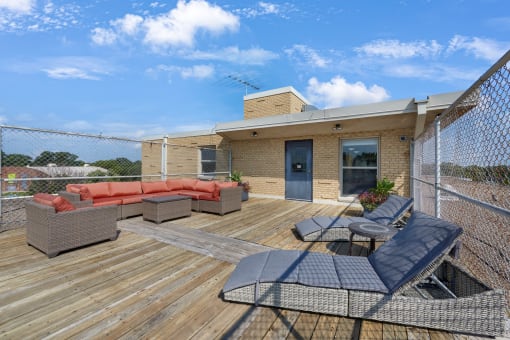 the deck of a home with furniture and a fence