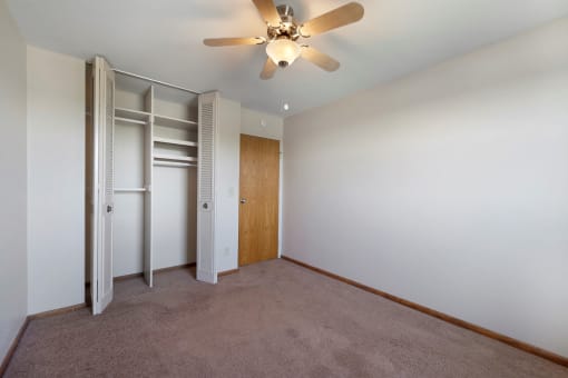 a bedroom with a closet and a ceiling fan