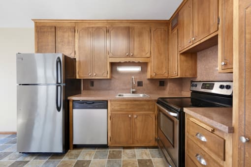 a kitchen with wooden cabinets and stainless steel appliances
