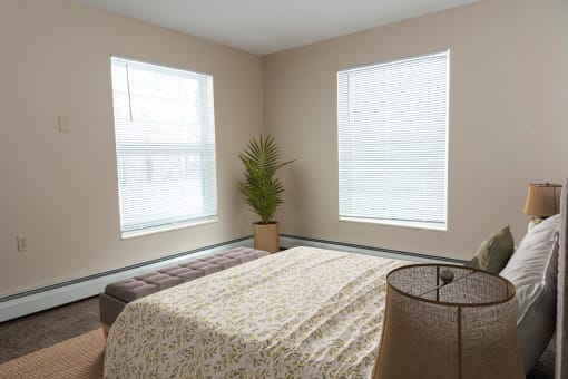 a bedroom with two windows and a large bed  at Briarcliff Apartments, a 55+ Community, Minnesota, 55115
