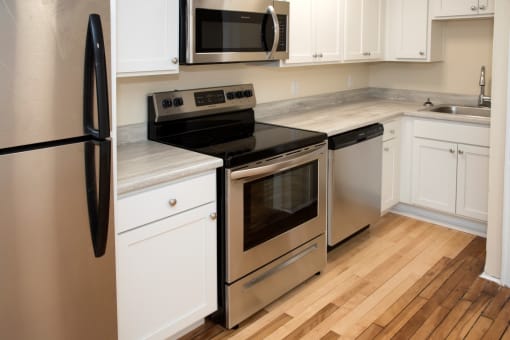 a kitchen with stainless steel appliances and white cabinets