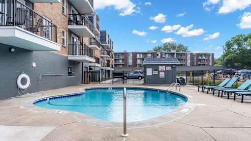 A swimming pool in a residential area surrounded by buildings.