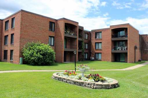 A brick building with a flower bed in front.