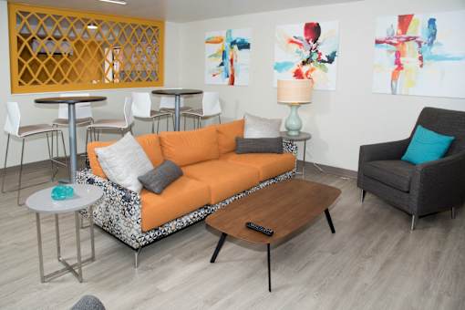 A laundry lounge with a sofa, chairs, and a coffee table.