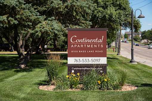 A sign for Continental Apartments is displayed in a landscaped area.