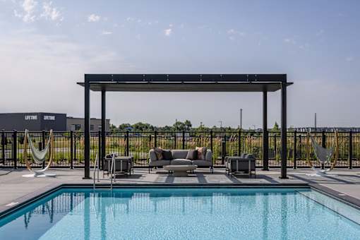 A pool with a hammock and a canopy.