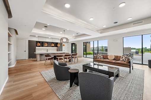 A modern living room with a dining area and a kitchen in the background.