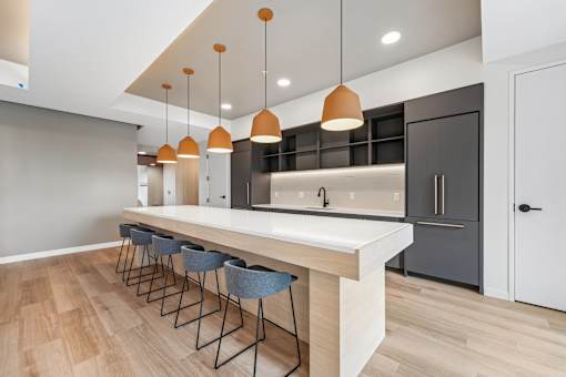 A modern kitchen with a long island and bar stools.