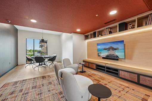A room with a television and a table with chairs.