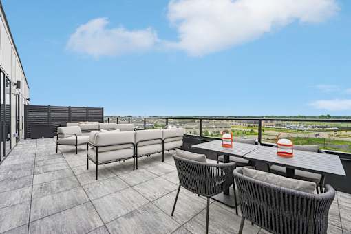 A patio with a table and chairs overlooking a field.