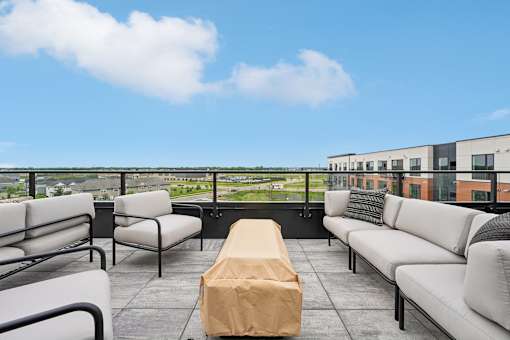A patio with a table and chairs overlooking a cityscape.