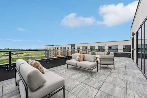 A balcony with two couches and a table.