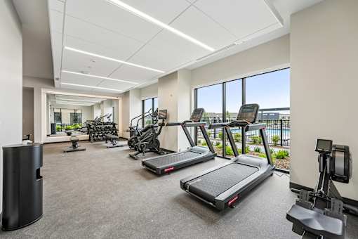 A gym with treadmills, exercise bikes, and other equipment.