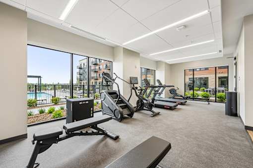 A gym with treadmills, elliptical machines, and other equipment.